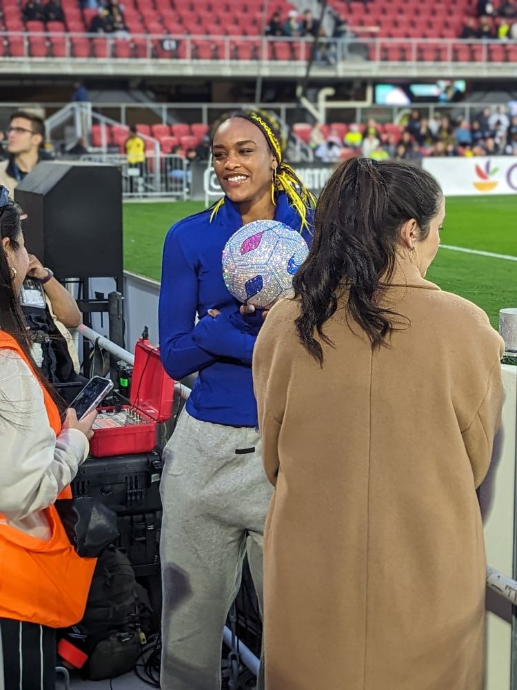 Aaliyah Edwards holding a jewel encrusted soccer ball at the Washington Spirit Home opener.