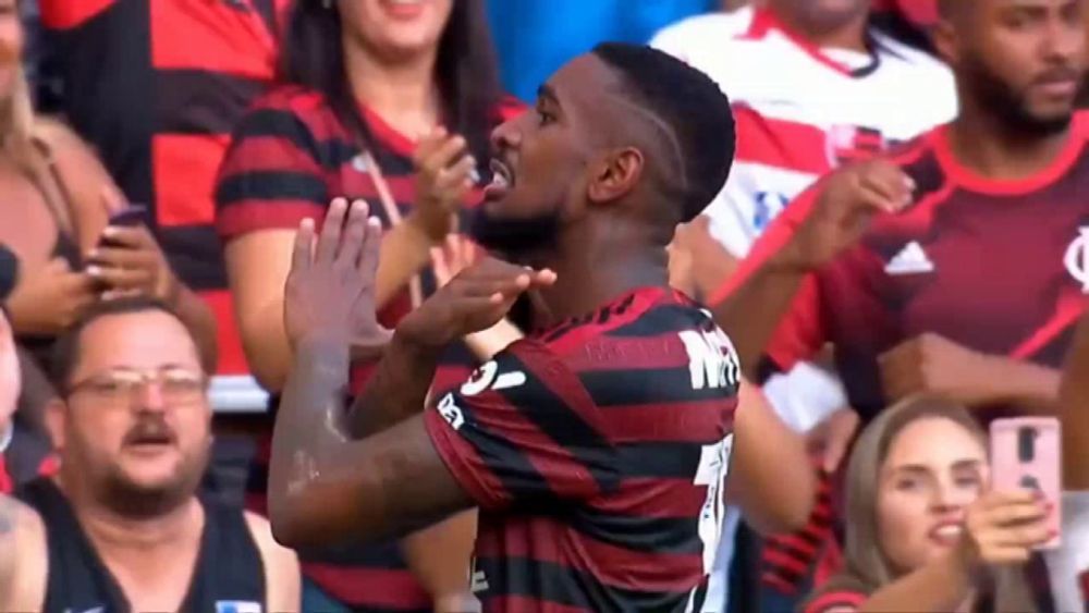 a soccer player is standing in front of a crowd of people applauding .