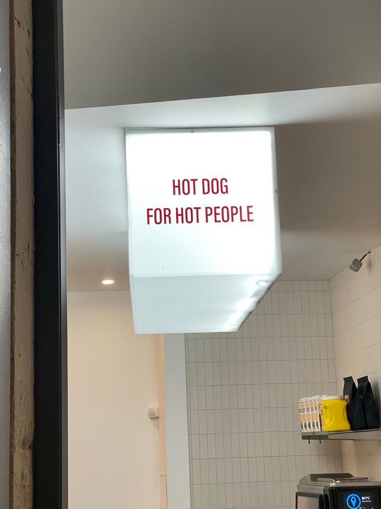 Picture of a store sign that says hot dog for hot people.