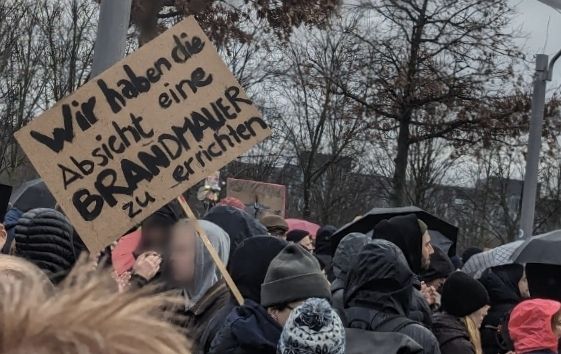 Bild von der 2024er Demo, viele Mützen und ein Schild "Wir haben die Absicht eine Brandmauer zu errichten"