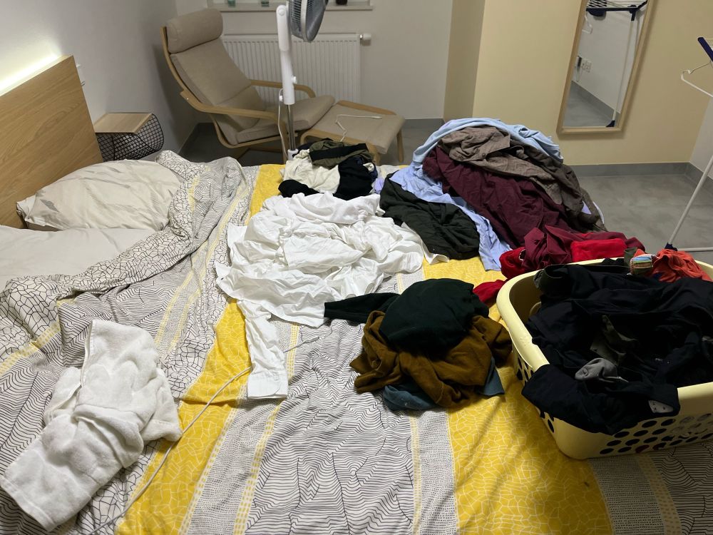 Pile de vêtements sur un lit mal fait