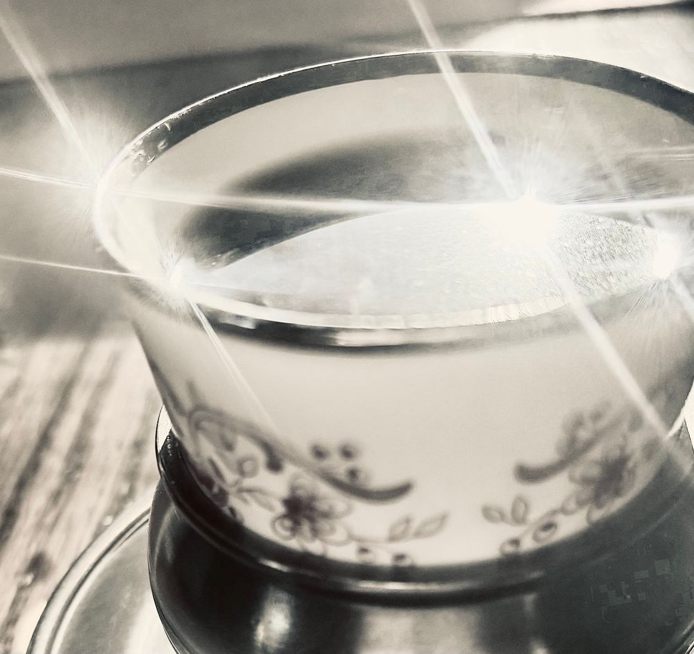 Rays of light reflecting on the top of a small espresso cup.