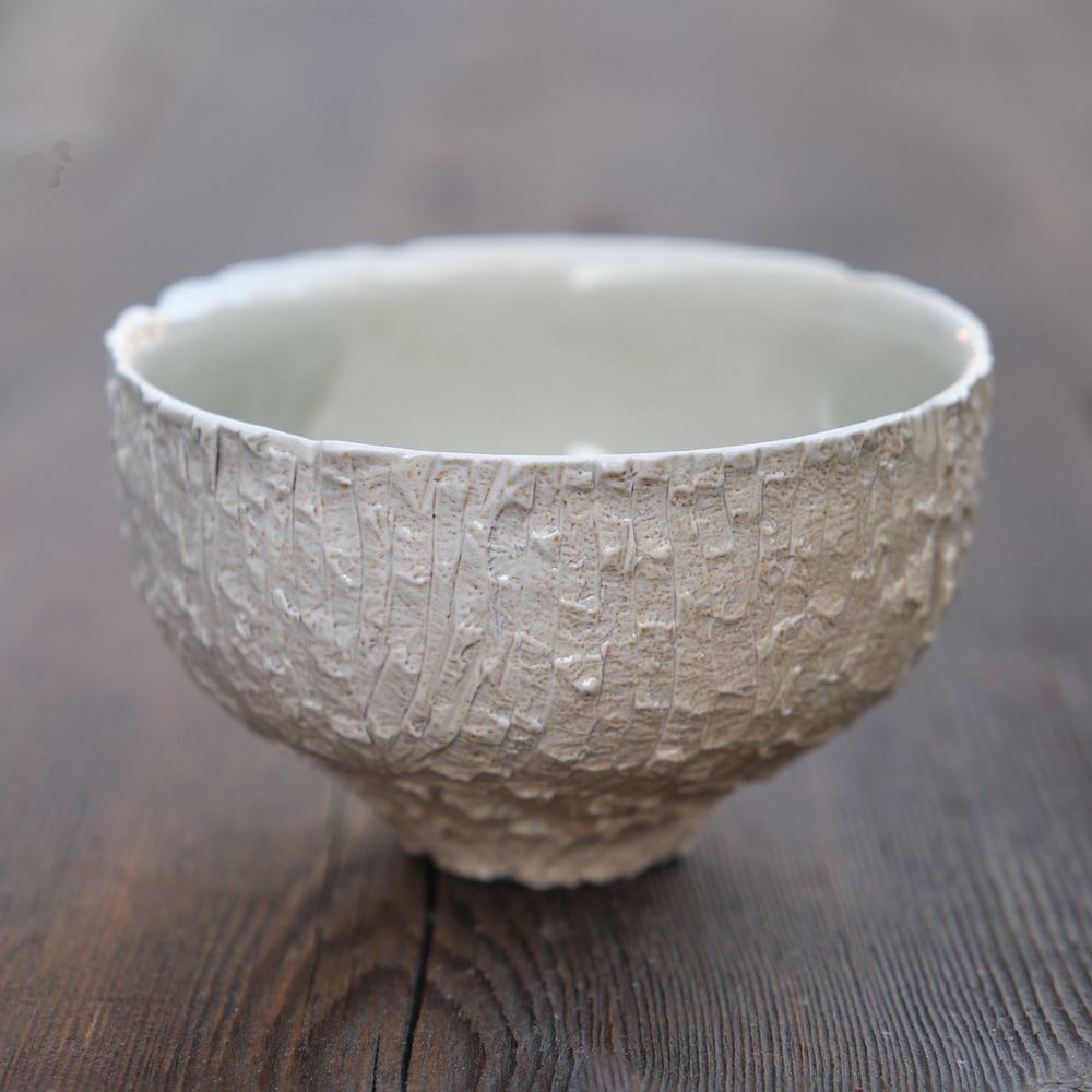 Front of teabowl. The chawan was thrown thick, allowed to dry to hard leather hard, then siced and torn with a razor to create the texture. The salt added to the firing gives the texture a smooth glossy finish.