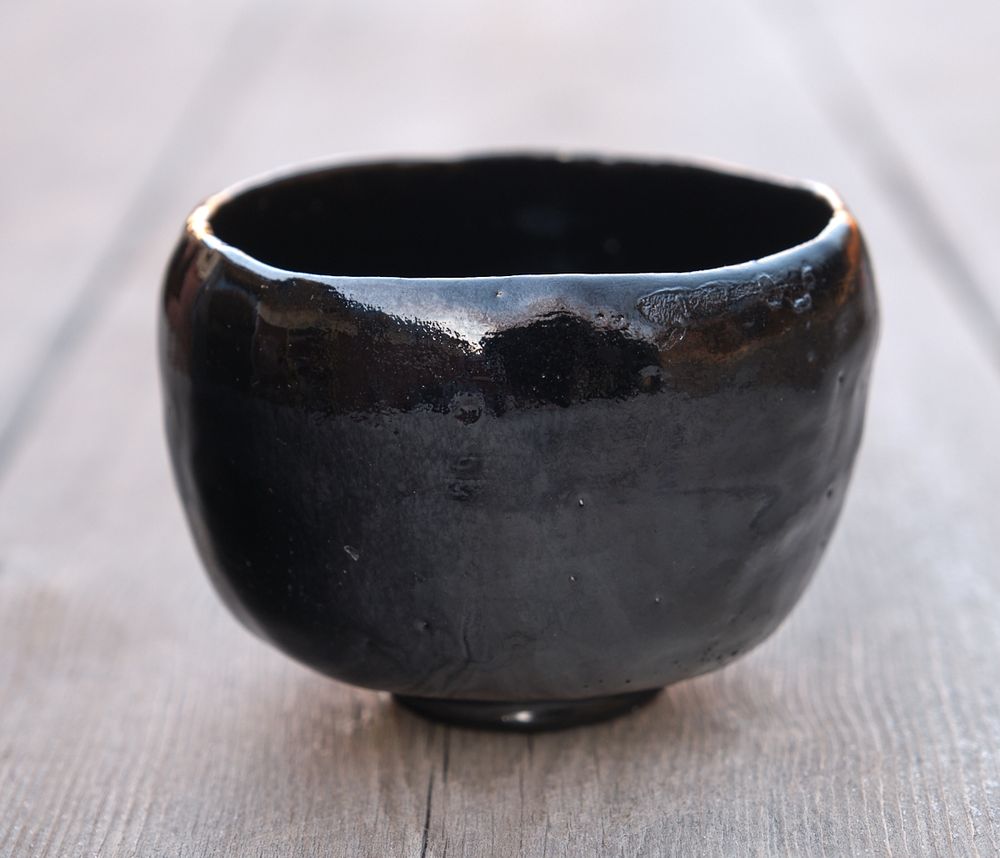 Front of the chawan. There's a surprising amount of variation in the glaze, and a scar on the rim from contact with another bowl in the kiln. Both help to define the front of the bowl.