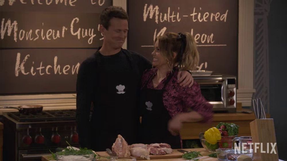 a man and a woman are standing in front of a chalkboard that says monsieur guy