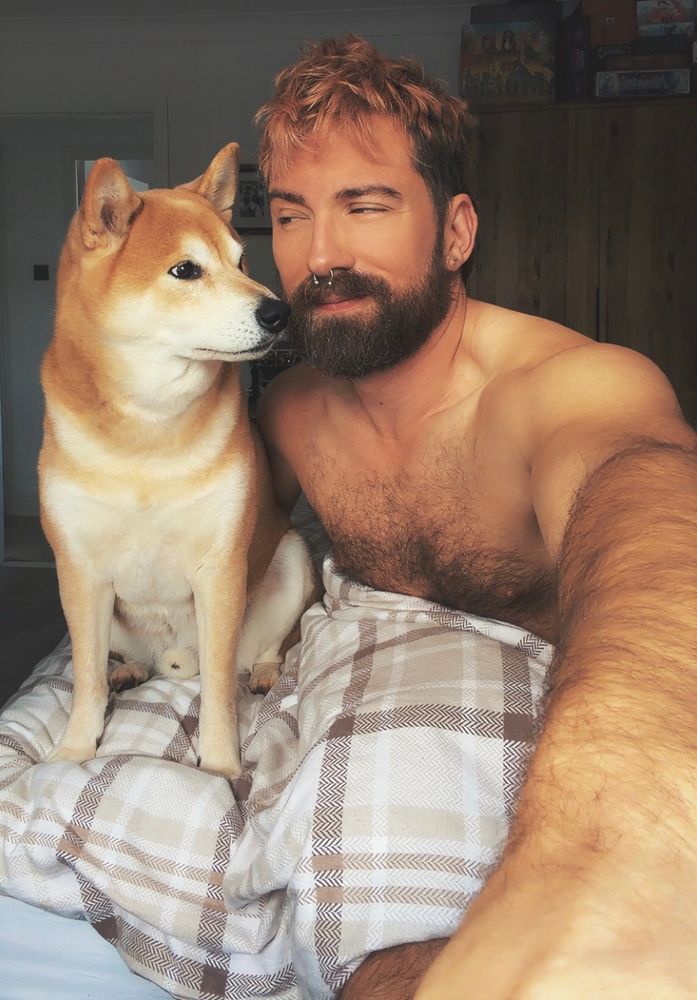 An Ashenbubs spending an extra hour in bed with his Shiba Inu, Bowser, both giving each other the side-eye. 