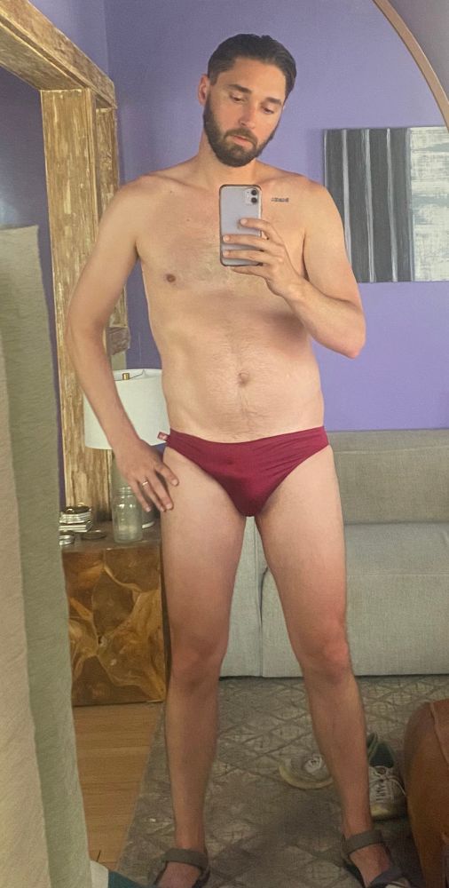 User standing in front of a mirror in a red speedo 
