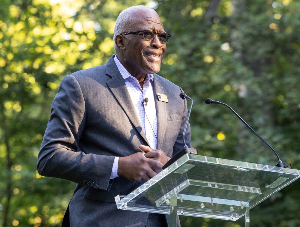 University of Washington President Robert J. Jones speaks at a podium outdoors at the President's Circle garden party.