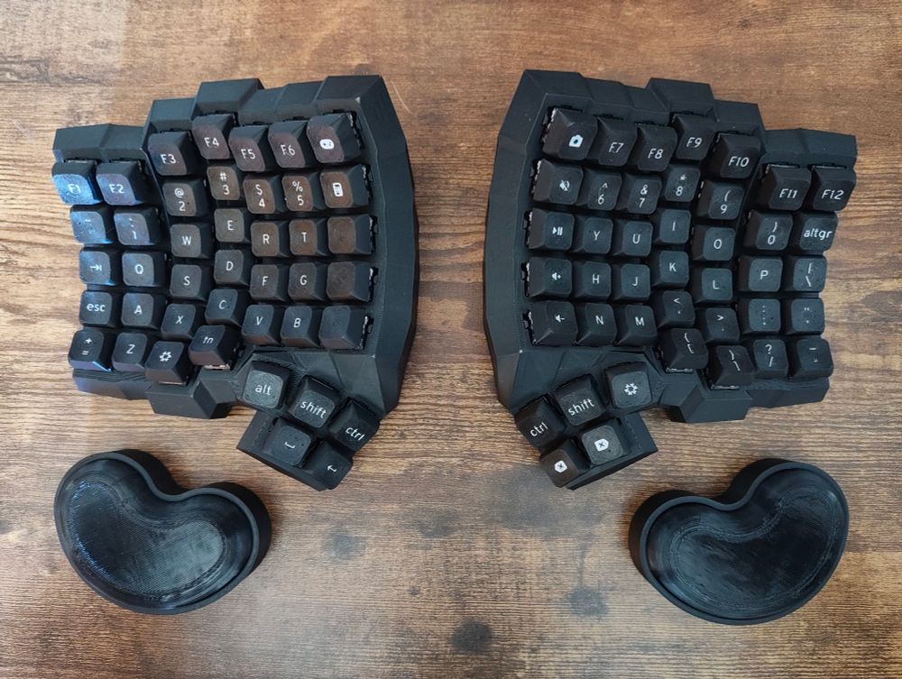 Black split and concave ergonomic keyboard with wrist rests.