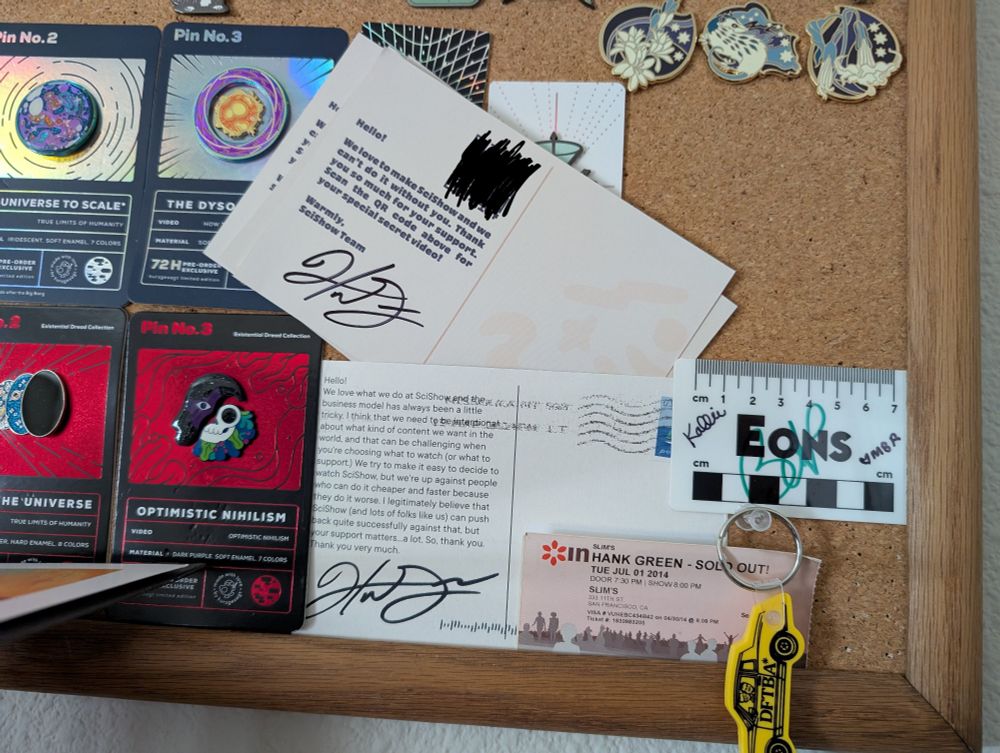 Postcards, pins and other memorabilia displayed on a brown corkboard