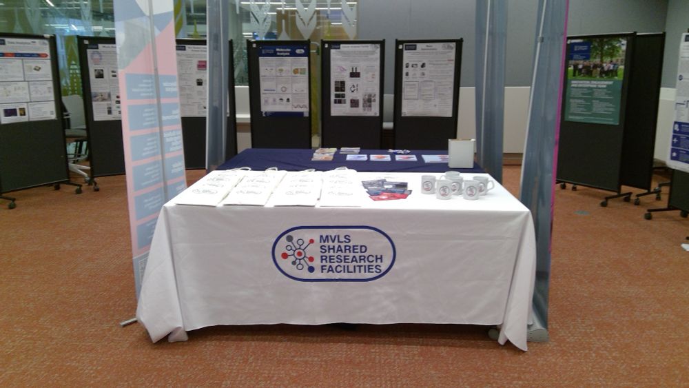 MVLS Shared Research Facilities exhibitor stand with posters displayed in the background.