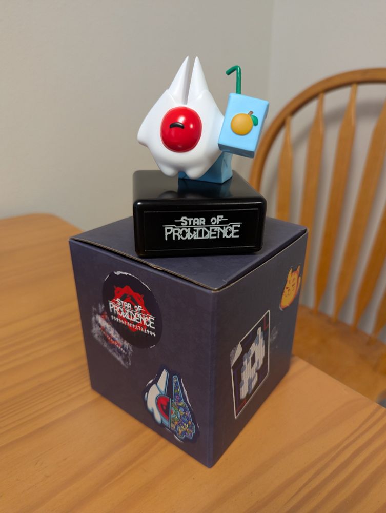 White and red toy on top of a cardboard box on top of a table 