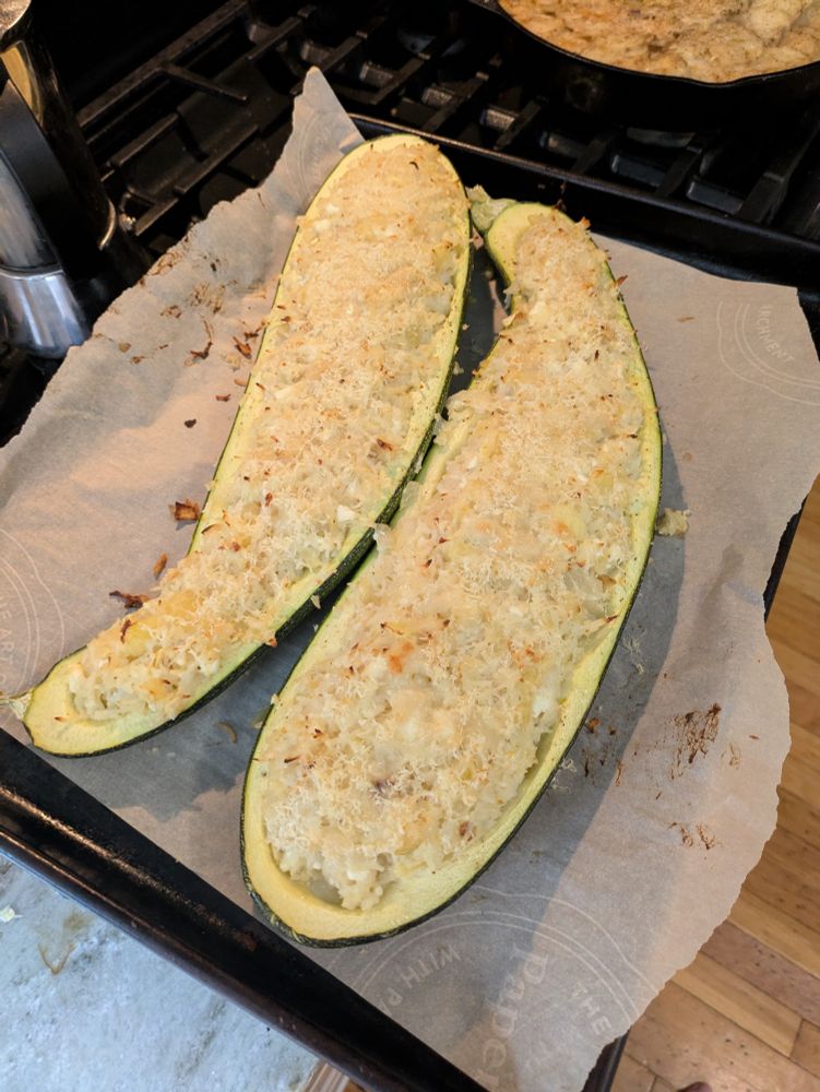 A giant zucchini split in half and stuffed with a cheesy rice mixture 