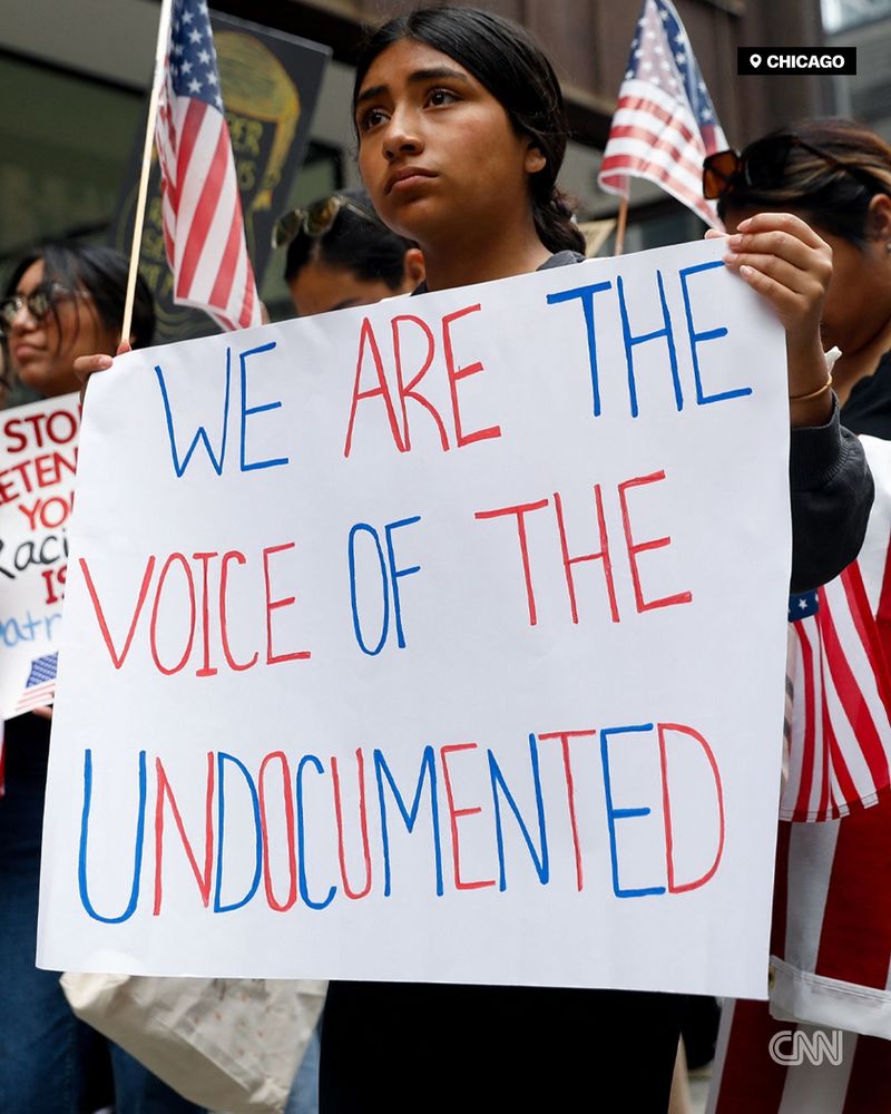 People convene for the start of a demonstration in downtown Chicago, with one holding a sign that reads 'We are the voice of the undocumented.' | Octavio Jones/Reuters