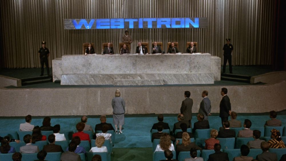a shareholders meeting prominently displaying a blue logo for something called Westitron 
