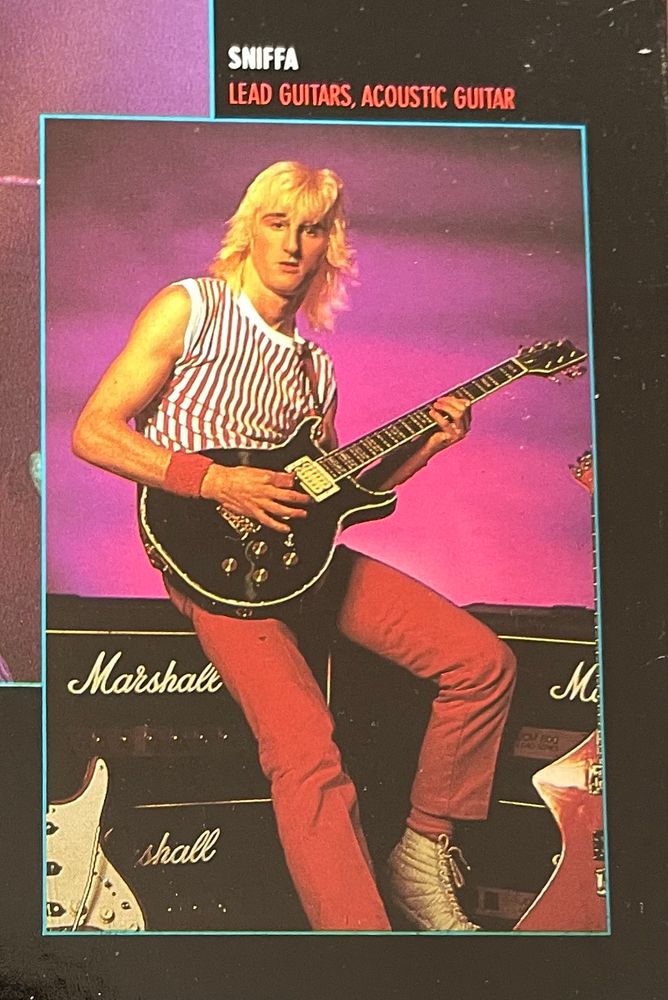 A guitarist called Sniffa - he has a blonde mullet, a black guitar, sitting on Marshall amps, he has red trousers