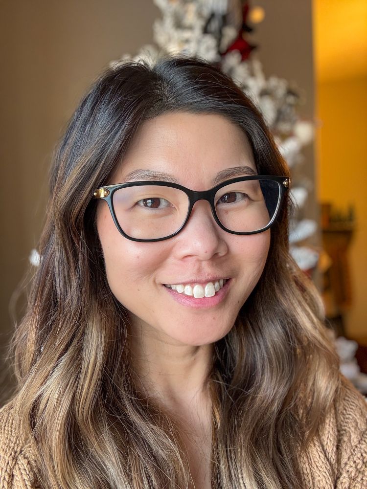 Photograph of a Korean woman with black glasses and brown highlighted hair. 