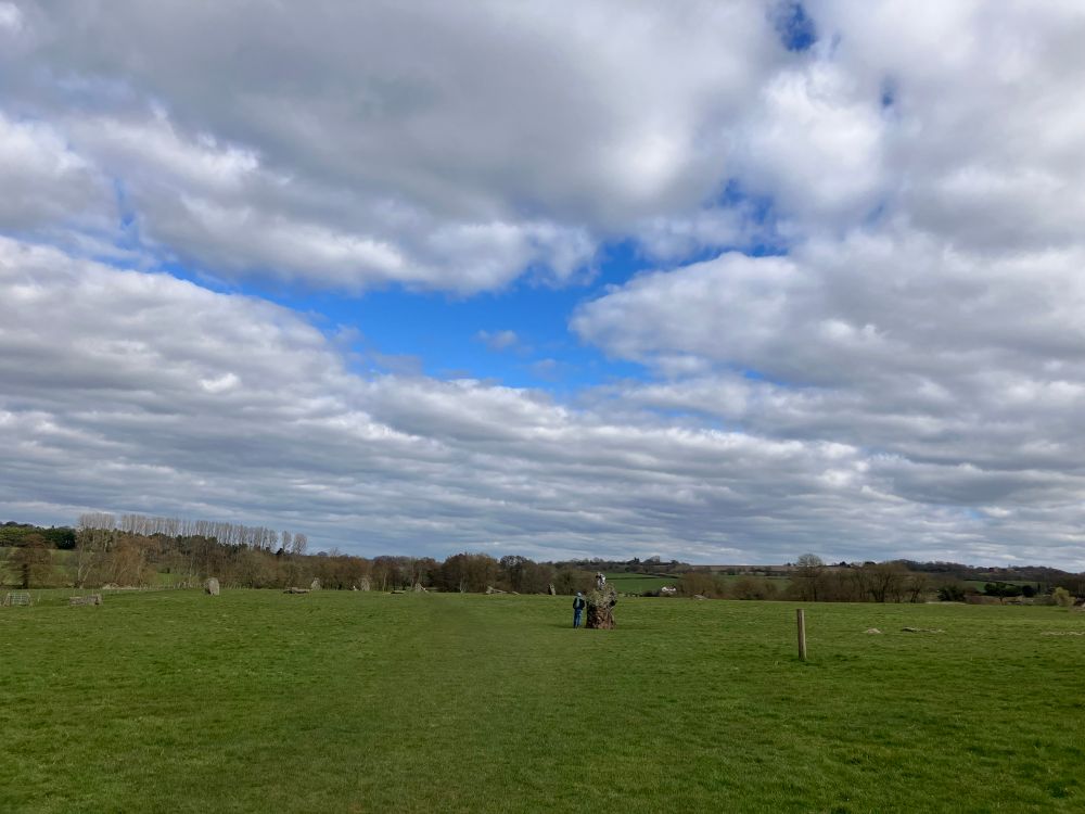 Wide shot of Stanton Drew standing stone circle, sky with cumulus clouds.