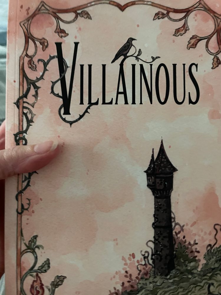 A large paperback book with a peach cover and the title “Villainous”. There are thorny vines running up one side opposite a tall black stone tower. 