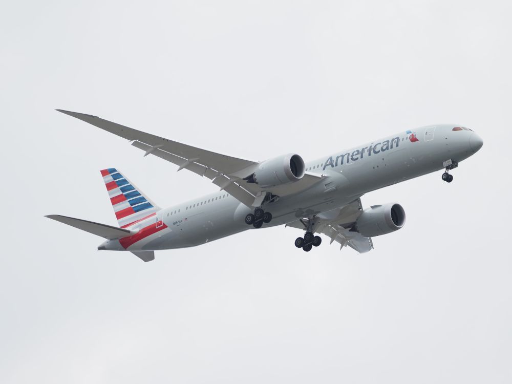 An American Airlines Boeing 787 Dreamliner against a gray sky.
