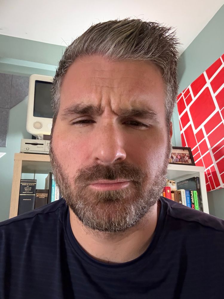 A selfie of me in my home office. Brow is furrowed.