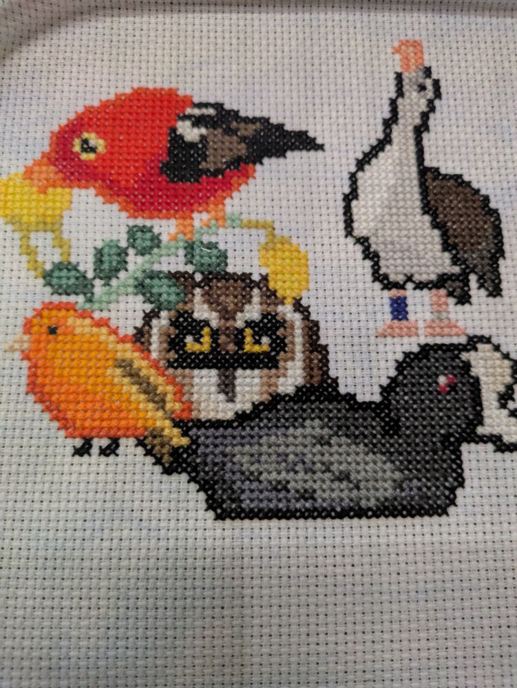 Cross stitch group now featuring a Pueo face.