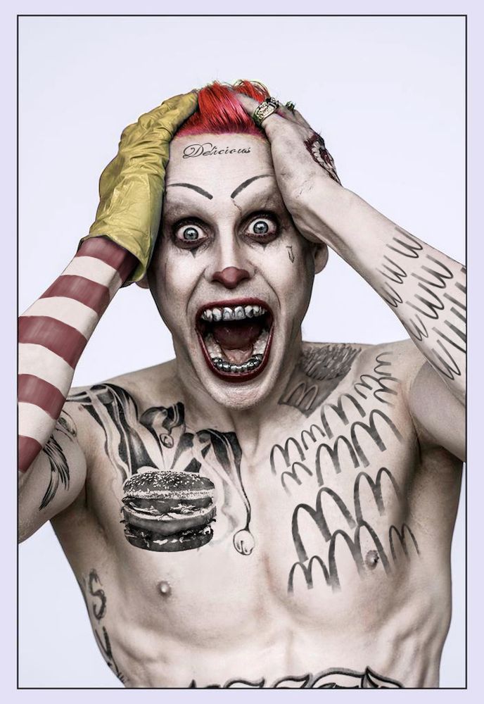 An image of Jared Leto's joker from the film SUICIDE SQUAD. He's been photoshopped to be covered in McDonald's related tattoos, and his hair, glove, and arm have been re-tinted to be Ronald McDonald colors like red and yellow.