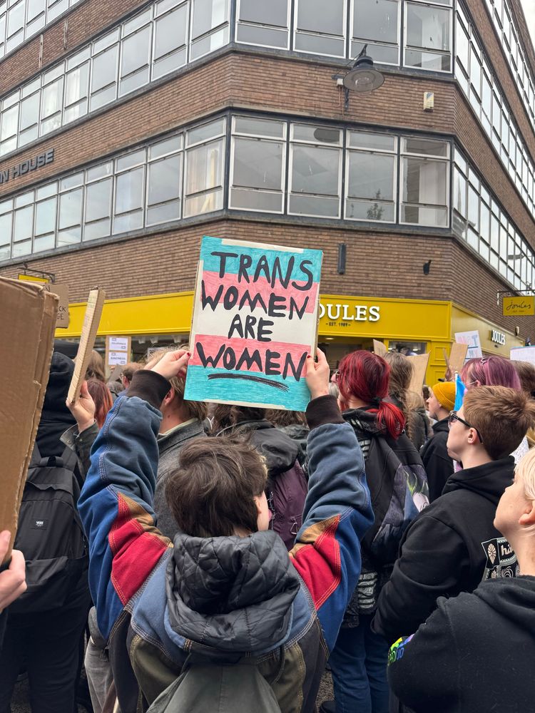 Person holding a trans women are women sign