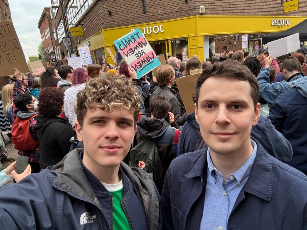 Joe and Nate with people protesting in the background