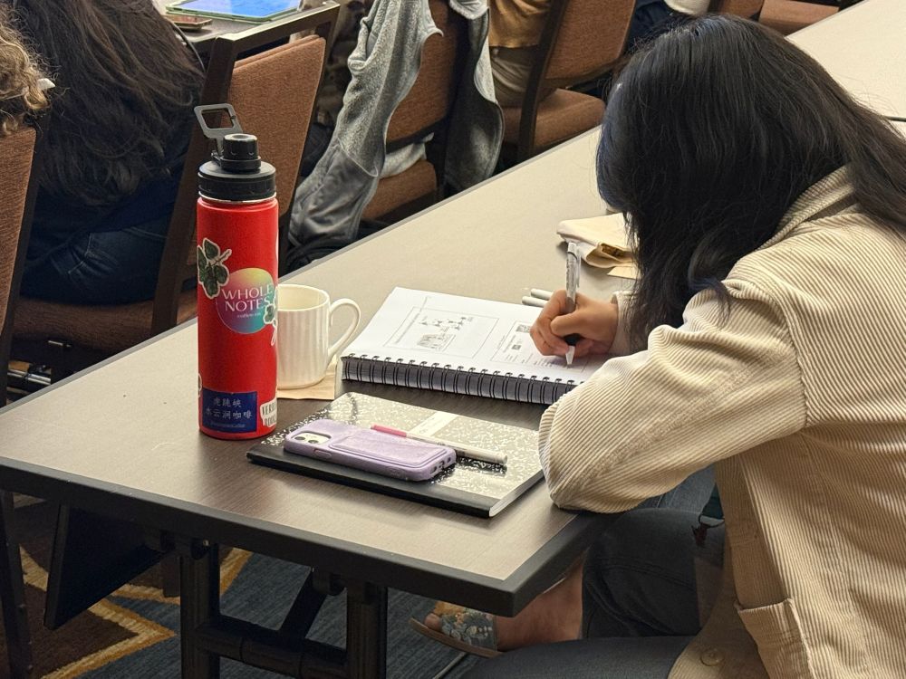 Photo of attendee of AAI Introductory Course in Immunology taking notes during lecture. 