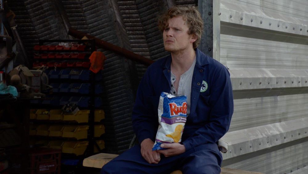 Daryl from the Canadian television show “Letterkenny” holding a bag of Ruffled All Dressed Chips