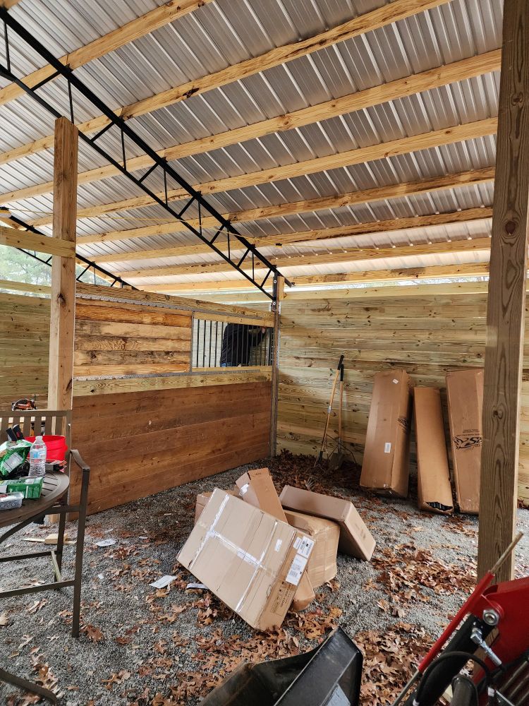 Barn under construction, with outside walls and one half grilled dividers installed