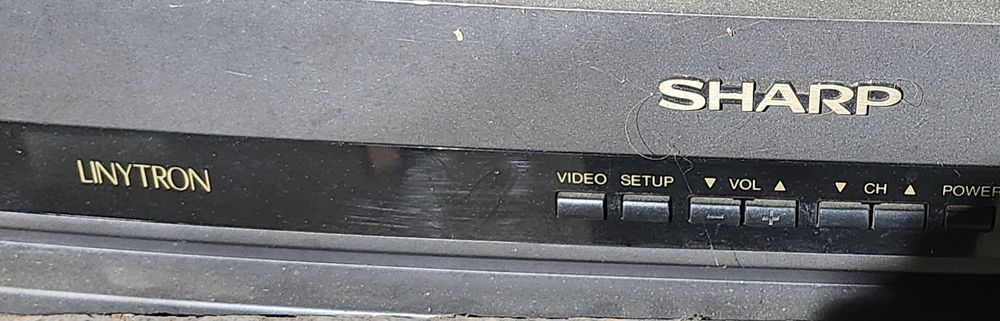 Closeup on the TV's Sharp logo with the name "LINYTRON" closeby