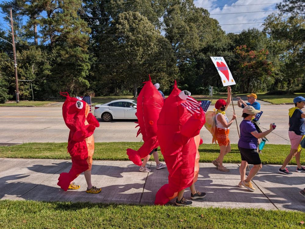 Three people dressed up as crawfish during the No Kings march in Baton Rouge