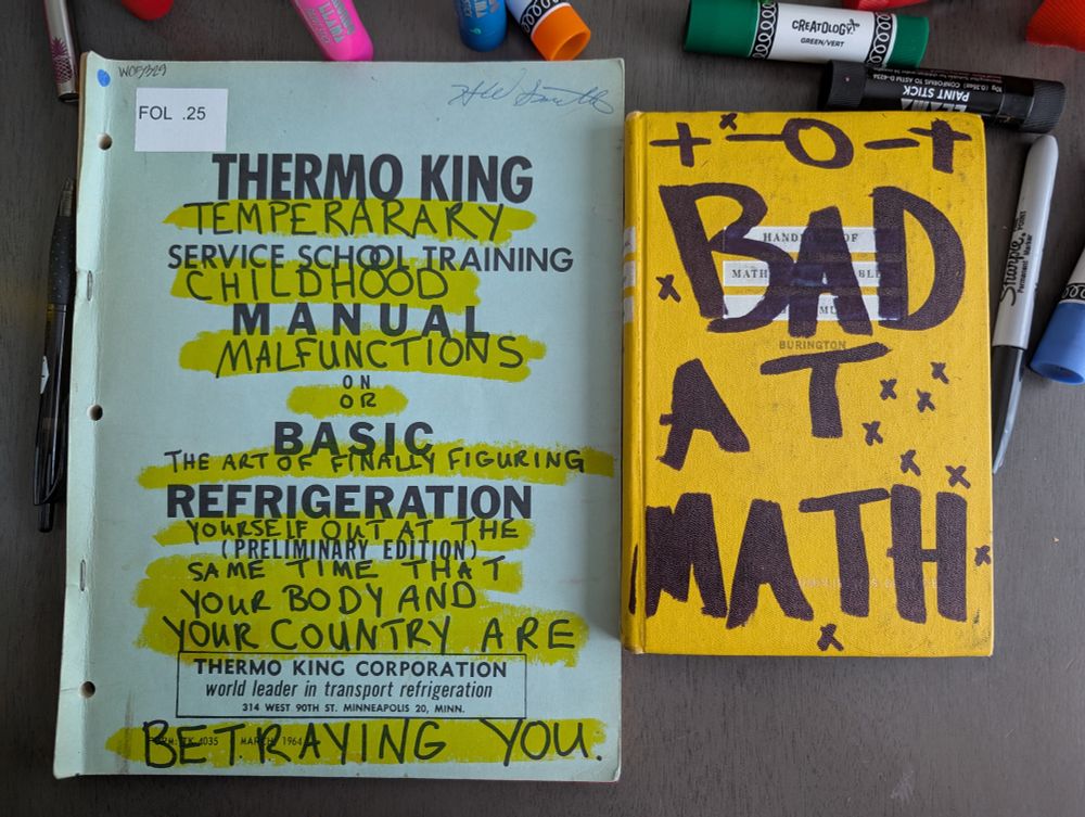 Old books scribbled on and surrounded by art supplies so they may be used as art journals.