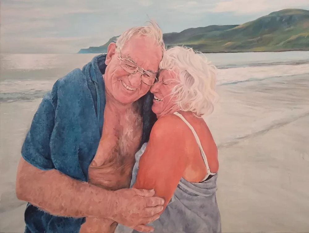 Oil painting of a couple laughing lovingly on a beach 