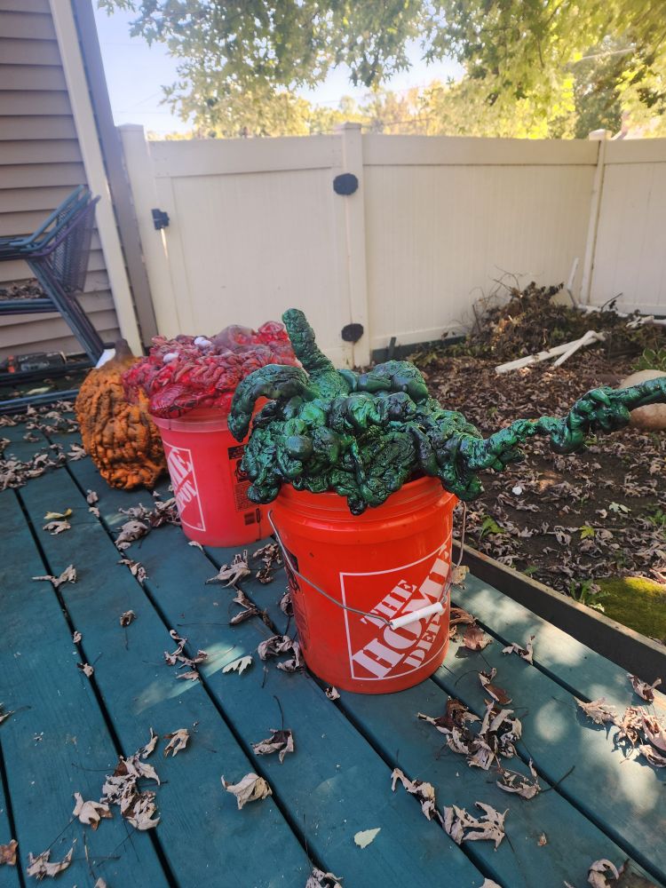 2 bucket toppers. One is green slime. The other is gore