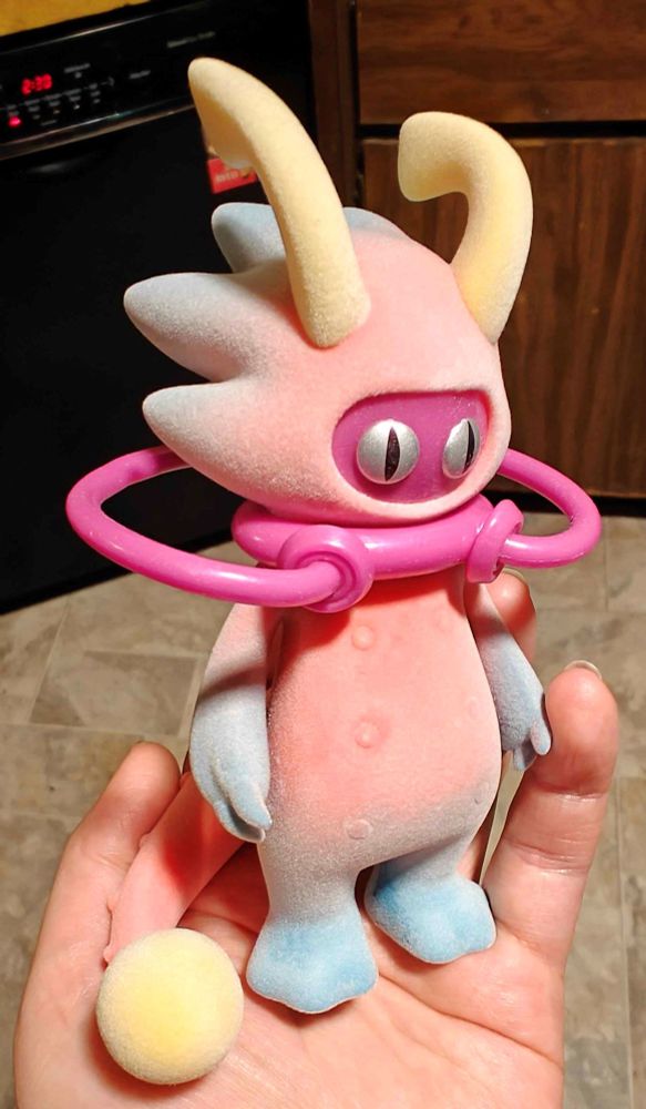 a flocked blind box figurine being held to the camera
