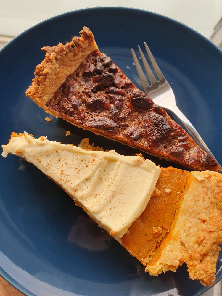 two slices of pie (pecan and pumpkin) on a blue plate
