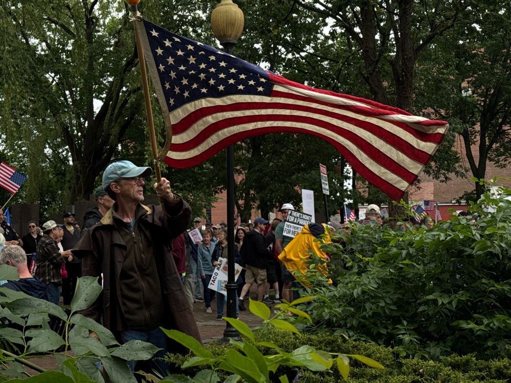 Man waving American flag at the No Kings Rally in Lowell.