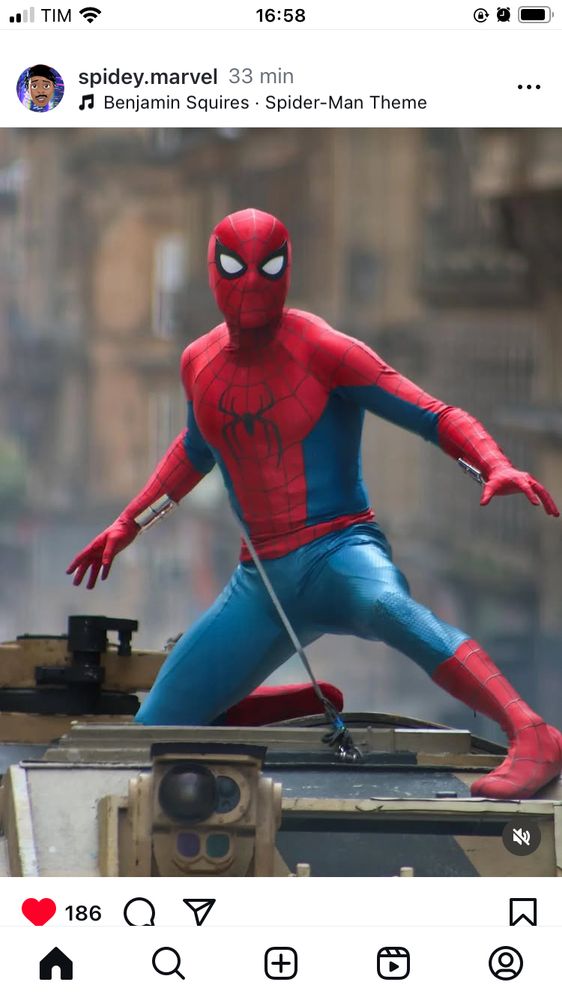 homem aranha em cima de um tanque, foto tirada no set de gravação, está de dia e o uniforme é bem parecido com o do quadrinho 