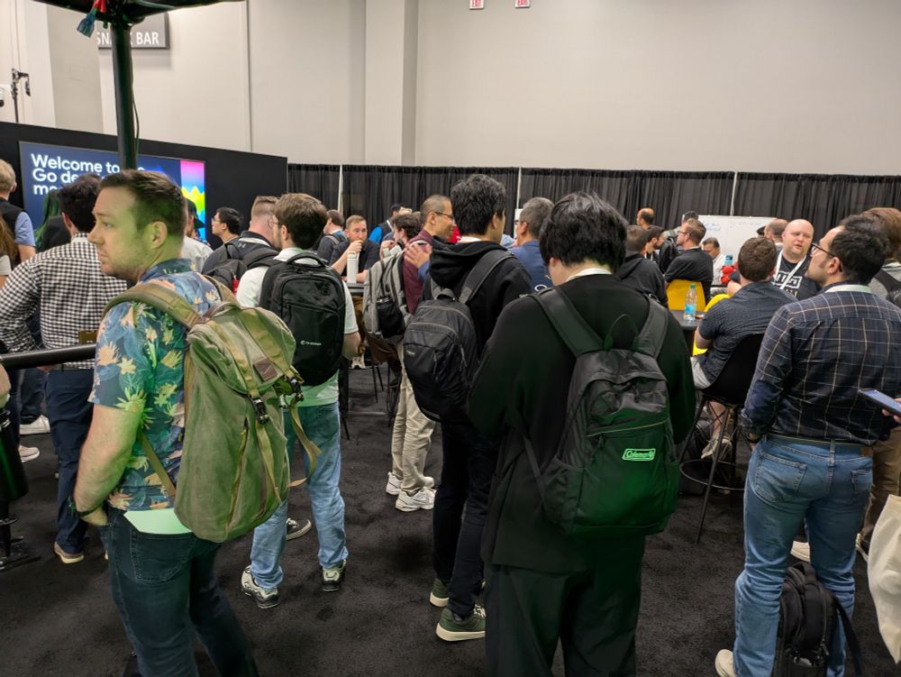 A large crown stands around chatting at the Go Developers Meetup!