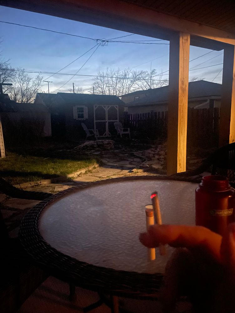 A hand holding a lit joint.