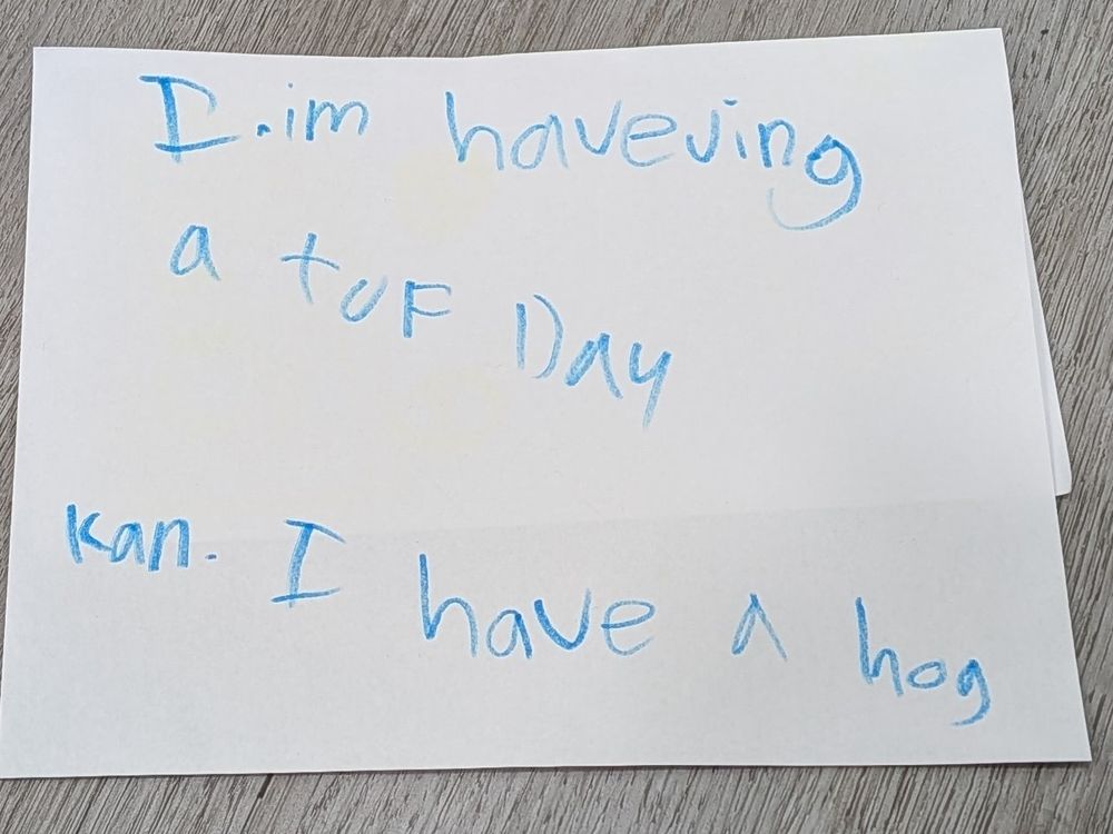 Written in blue marker, in kid's creative spelling: "I.im haveving a tuf day kan I have a hog" 