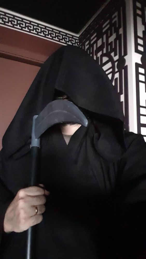 Foto minha como a "Morte". Estou segurando uma foice e vestindo já capuz.