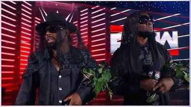 Two wrestlers in mourning black on the set of WWE Monday night raw. 