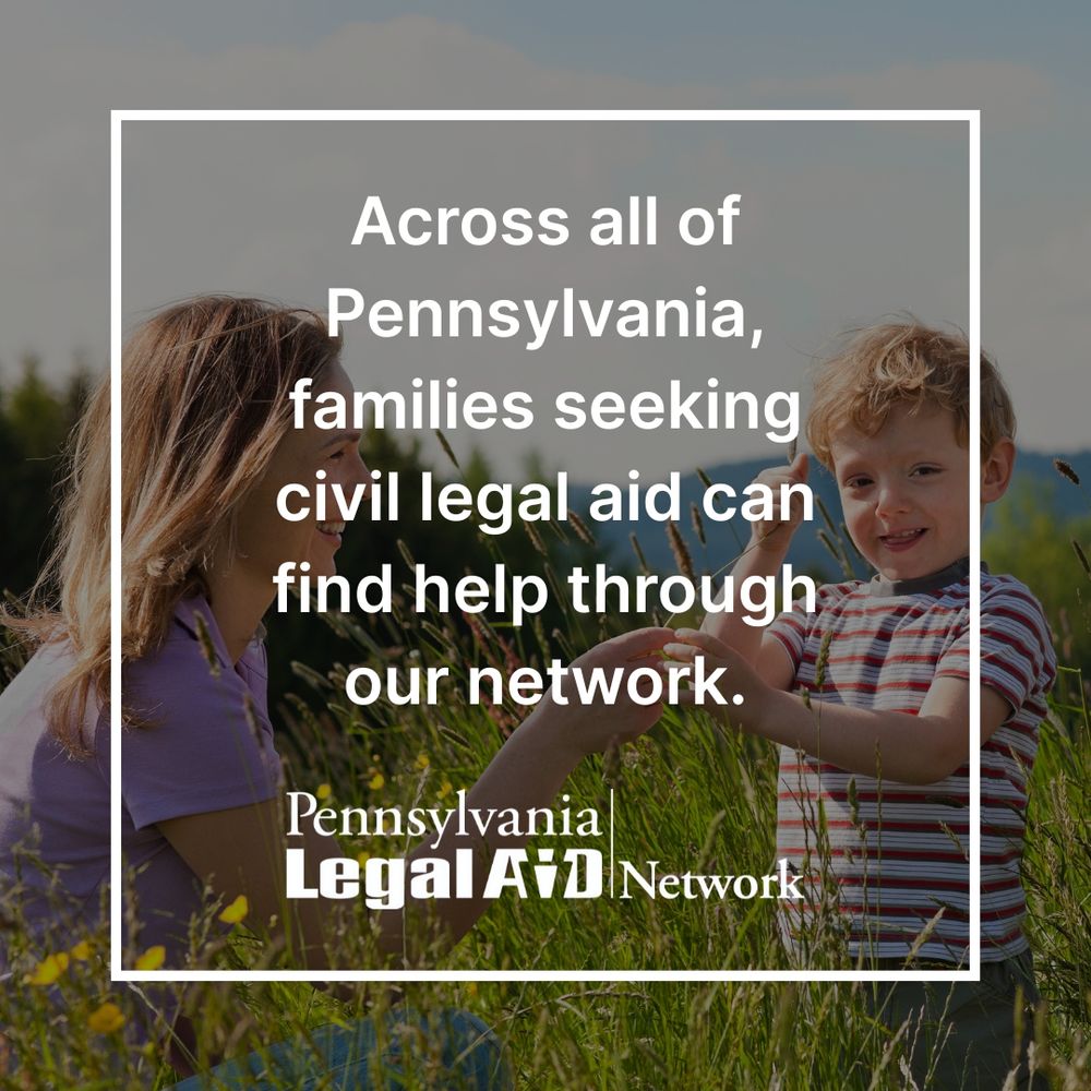 This is an image of a mother and her young son outdoors in daytime. There is tall grass, wildflowers, and mountains in the background. The mother wears a purple shirt while her son wears a striped shirt, and they appear to be exploring and playing together in the meadow. White text over the image reads: 'Across all of Pennsylvania, families seeking civil legal aid can find help through our network.' The Pennsylvania Legal Aid Network logo appears in white at the bottom.