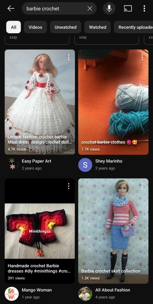 Captura de pantalla de YouTube con la búsqueda "Barbie crochet" aparece varios vídeos en formato short mostrando vestidos y cardigans sobre muñecas barbie. 