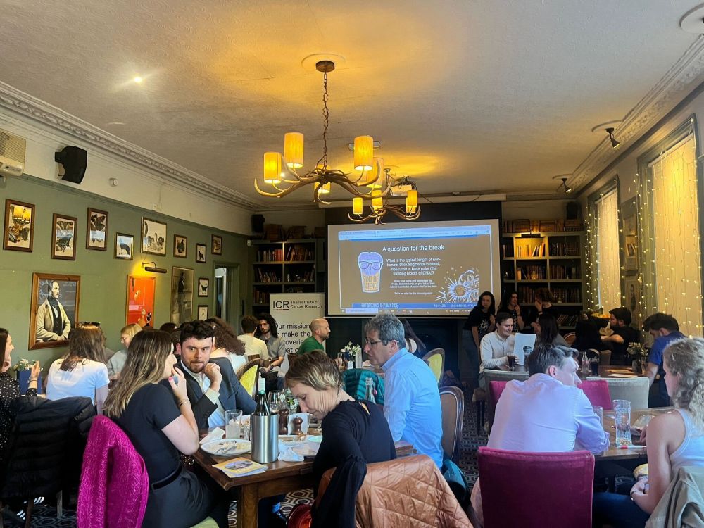 Presenting in the pub at Pint of Science. Wide shot where the audience is visible.
