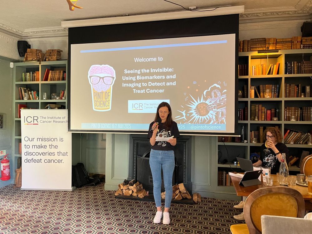 Presenting in the pub at Pint of Science. The title slide is on the projector behind the presenter.